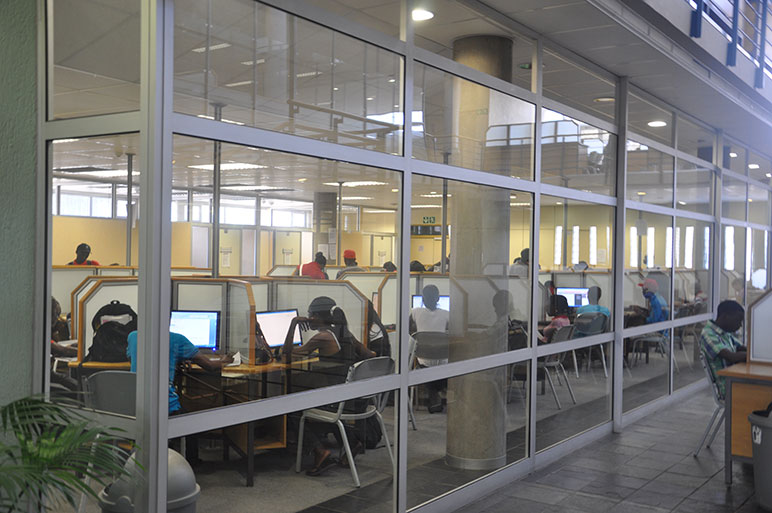 Students working at computer carrels behind glass